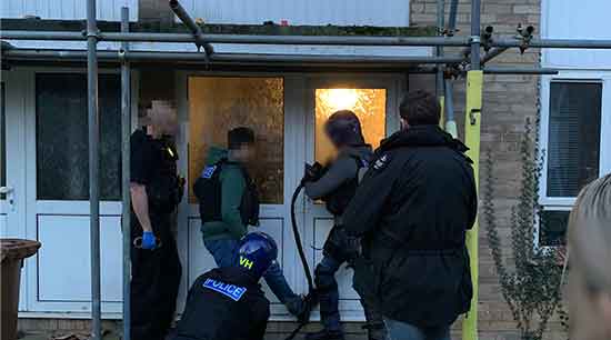 Officers forcing their way into house